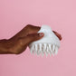 Silicone scalp massager product on a neutral background